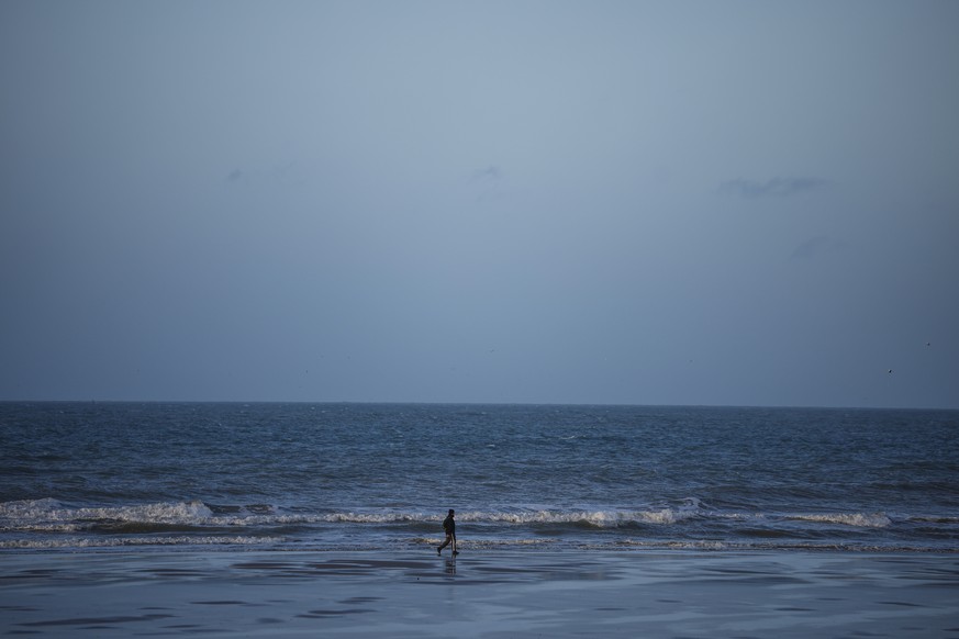 epa10323520 A man walks on the beach in Oye Plage, near Calais, France, 23 November 2022. On 24 November falls the 1st anniversary of the shipreck that killed 27 migrants trying to cross La Manche can ...