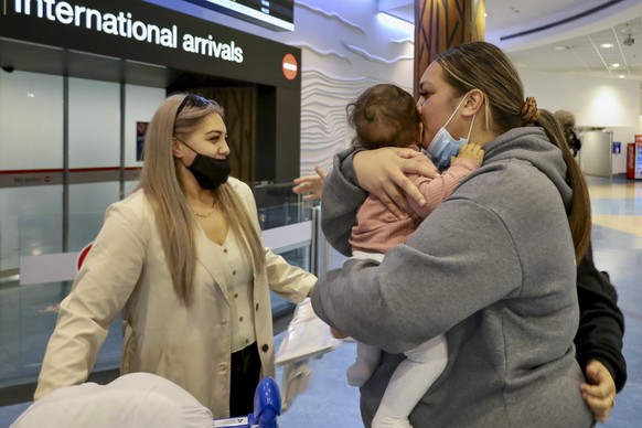 Families embrace after a flight from Los Angeles arrived at Auckland International Airport as New Zealand&#039;s border opened for visa-waiver countries Monday, May 2, 2022. New Zealand welcomed touri ...