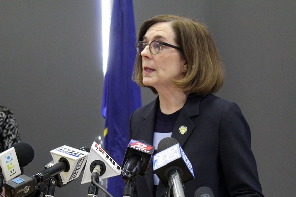 FILE - In this March 16, 2020, file photo, Oregon Gov. Kate Brown speaks at a news conference in Portland, Ore., to announce a four-week ban on eat-in dining at bars and restaurants, due to COVID-19,  ...