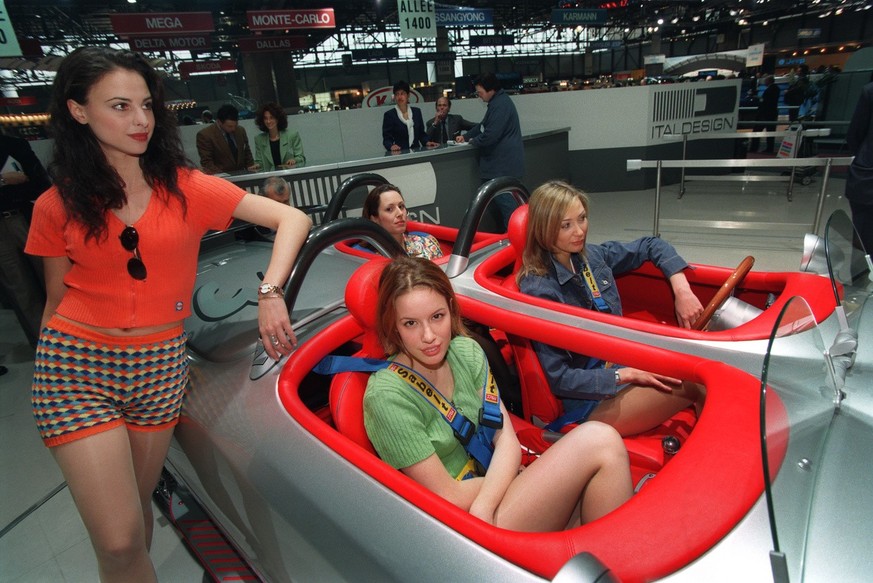Exhibition hostesses sit in an Italdesign/Giugiaro Roadster 4 Seats at the 66th Geneva International Motor Show, taken on March 6, 1996. (KEYSTONE/Str): FILM]