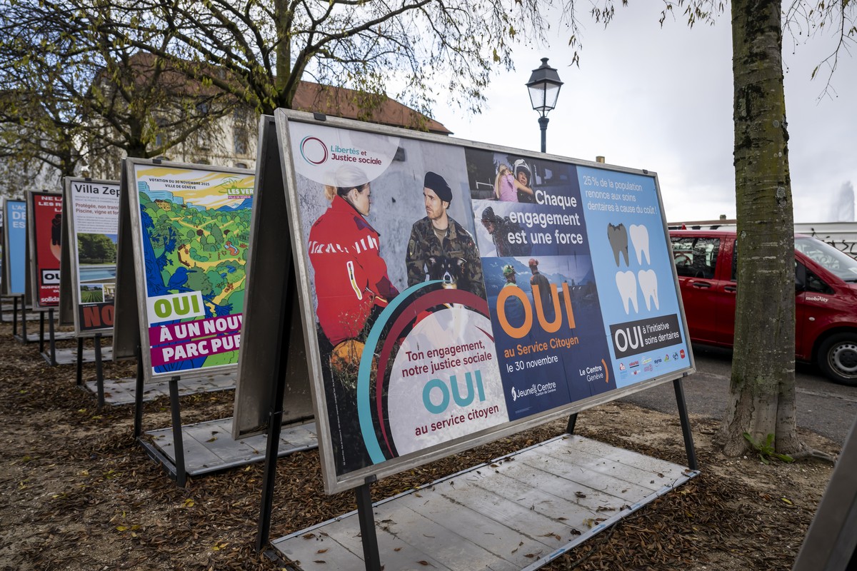 Une personne passe devant les affiches des partis politiques et des associations donnant leurs mots d'ordre pour les votations cantonale, federale et une votation municipale, du dimanche 30 novem ...