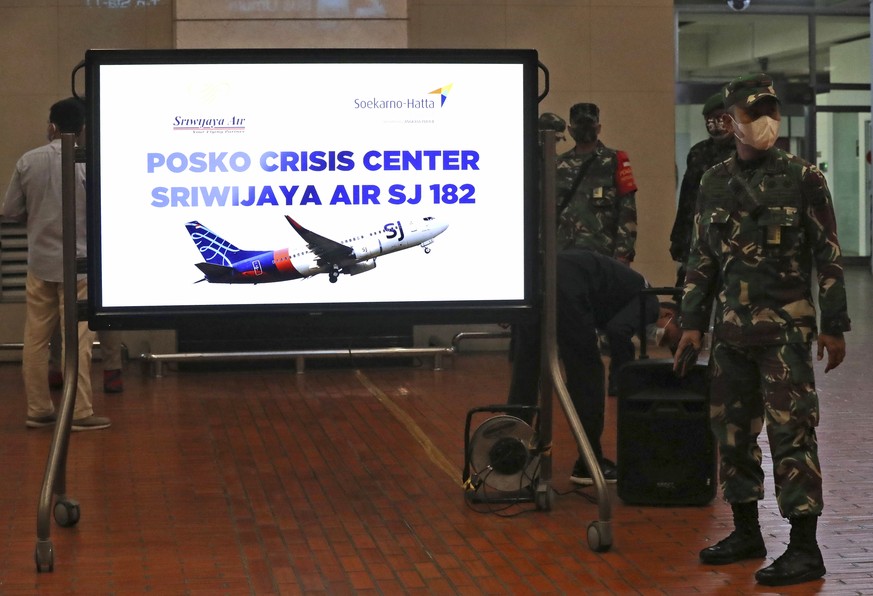 Indonesian soldiers stand near a crisis center set up following a report that a Sriwijaya Air passenger jet has lost contact with air traffic controllers after take off, at Soekarno-Hatta Internationa ...