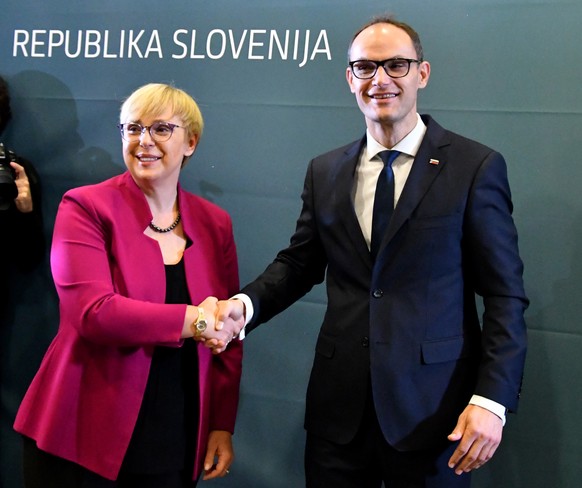 epa10304501 Natasa Pirc Musar (L), first female president-elect of Slovenia shakes hands with Anze Logar (R), the independent presidential candidate, after winning the elections, in Ljubljana, Sloveni ...
