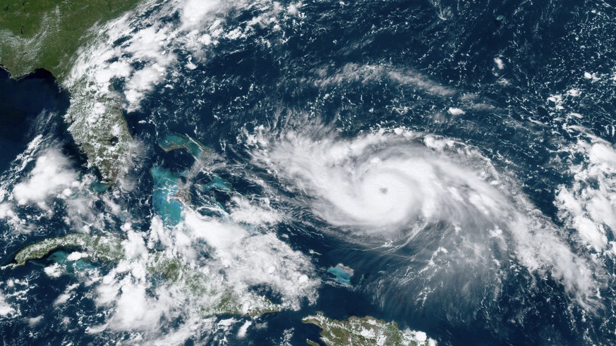 This GOES-16 satellite image taken Friday, Aug. 30, 2019, at 17:20 UTC and provided by National Oceanic and Atmospheric Administration (NOAA), shows Hurricane Dorian, right, moving over open waters in ...