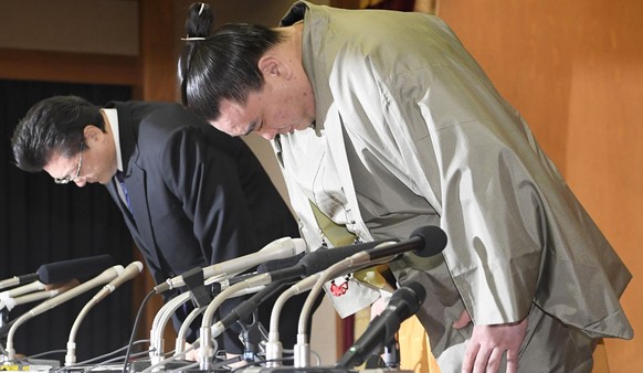 Mongolian grand champion Harumafuji with his stablemaster Isegahama, left, bows during a press conference to announce his retirement, in Dazaifu, southwestern Japan, Wednesday, Nov. 29, 2017. Harumafu ...