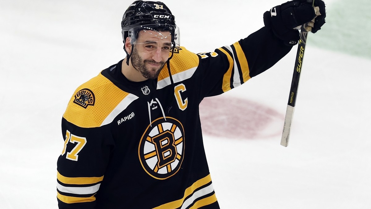 FILE - Boston Bruins' Patrice Bergeron raises his stick to the fans after losing to the Florida Panthers in overtime during Game 7 of an NHL hockey Stanley Cup first-round playoff series, Sunday, ...