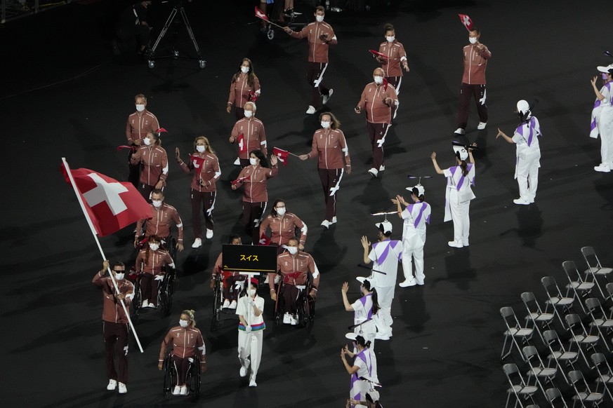 Athletes from Switzerland enter the stadium during the opening ceremony for the 2020 Paralympics at the National Stadium in Tokyo, Tuesday, Aug. 24, 2021. (AP Photo/Eugene Hoshiko)