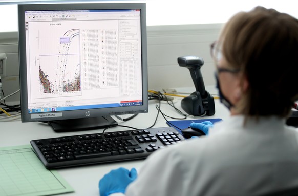 epa08715581 An employee analyses a positive corona test on her computer at the Chemical and Veterinary Investigation Office (CVUA) in Muenster, Germany, 02 October 2020. In the laboratory for veterina ...