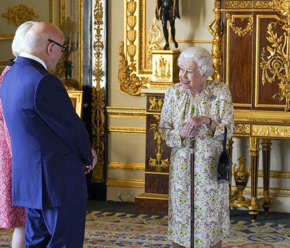 Britain&#039;s Queen Elizabeth II meets Pamela Harper and Dr Peter Harper from British craftwork company, Halcyon Days, to view a display of artefacts to commemorate the company&#039;s 70th anniversar ...