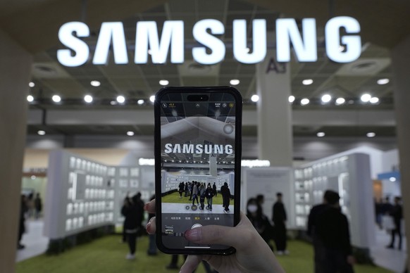 FILE - A visitor takes a picture of the logo of Samsung Electronics at its booth during The Semiconductor Exhibition 2024 at the COEX convention center in Seoul, South Korea, Wednesday, Oct. 23, 2024. ...