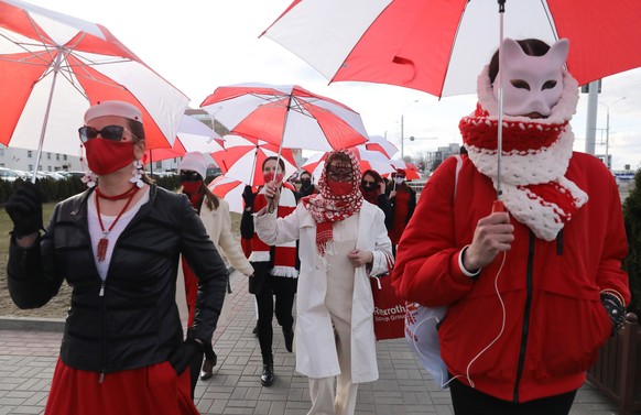 epa09118929 Belarusian women wearing clothes and holding umbrellas in colours of a Belarusian protest flag, march during a protest against the government and Belarusian President Lukashenko in Minsk,  ...