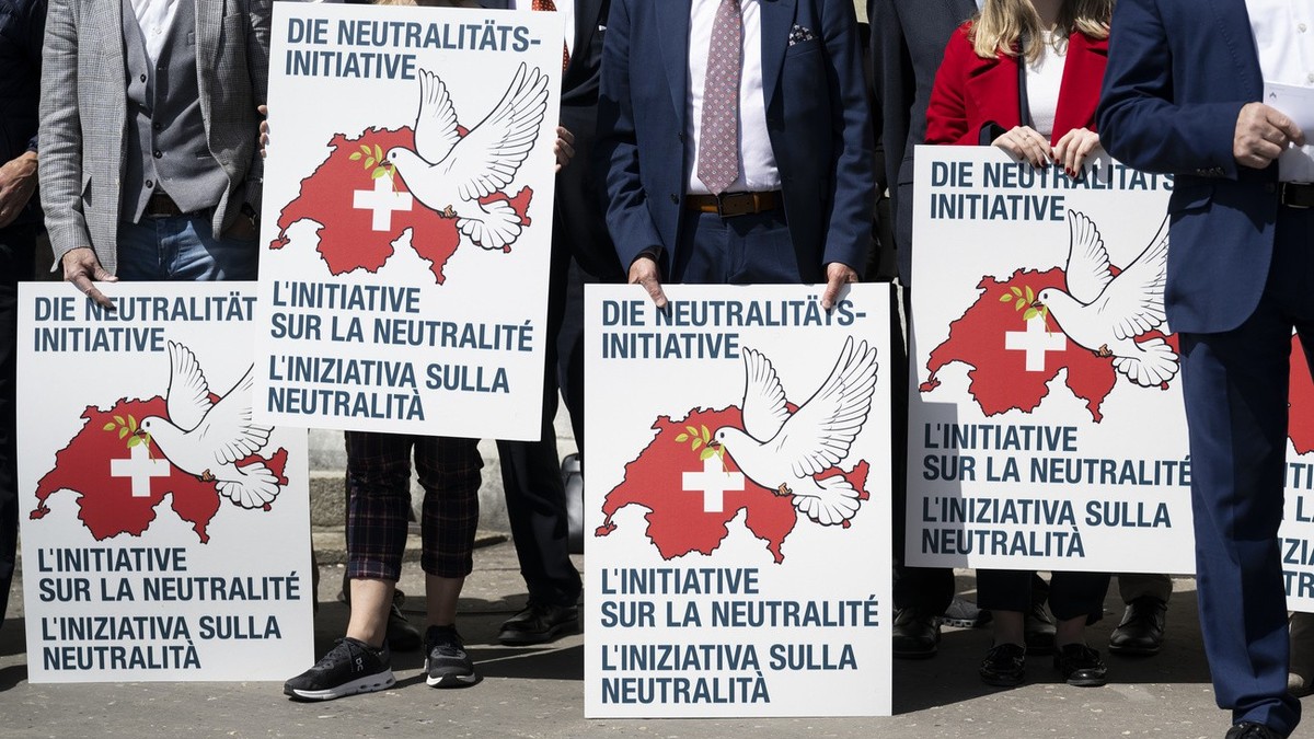 Unterstuetzer halten Plakate anlaesslich der Einreichung der eidgenoessischen Volksinitiative "Wahrung der schweizerischen Neutralitaet (Neutralitaetsinitiative)", am Donnerstag, 11. April 2 ...