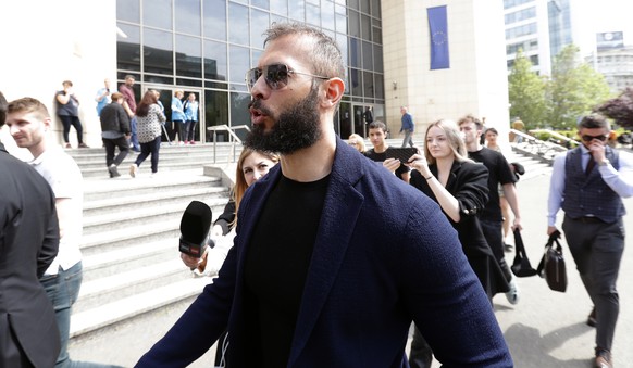 epa10638371 Former professional kickboxer and social media influencer Andrew Tate (C) is chased by journalists on the stairs of the court building after being presented to a judge for an extension of  ...