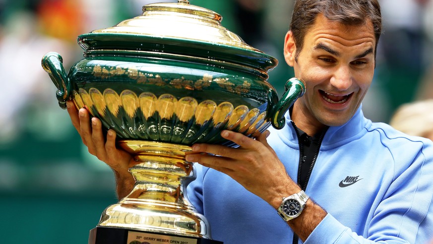 epa06049485 Roger Federer of Switzerland poses with his trophy after defeating Alexander Zverev of Germany in their final match of the ATP tennis tournament in Halle, Germany, 25 June 2017. EPA/TYLER  ...