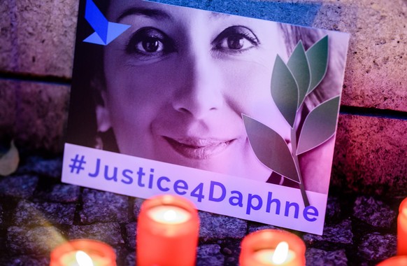 epa08011130 (FILE) &#039;Justice four Daphne&#039; is written on a cardboard showing a photo of Daphne Caruana Galizia, during a picket in front of the Maltese embassy for murdered journalist Daphne C ...