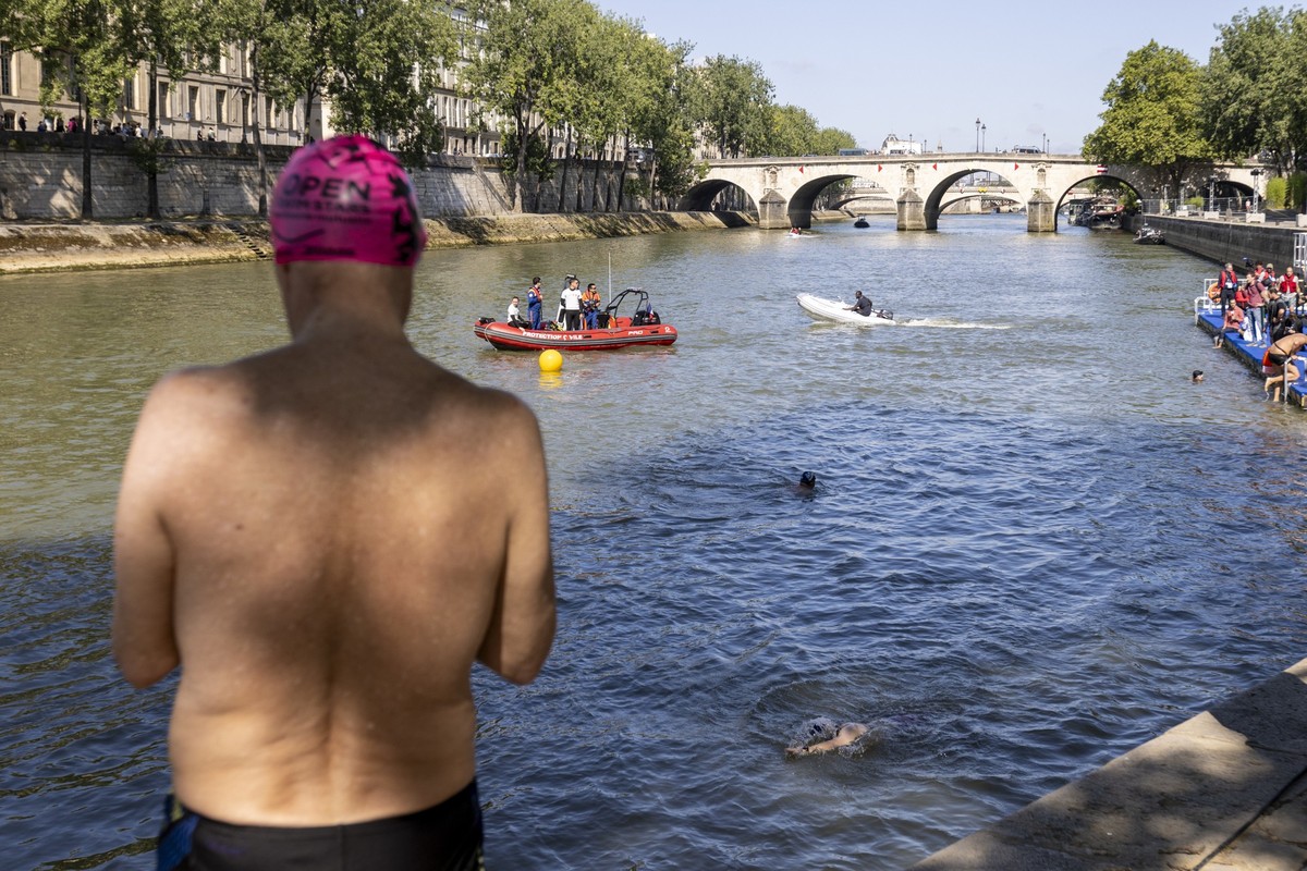 epa11483512 People swim in the Seine river after Paris Mayor demonstrated that it is clean enough to host the outdoor swimming events at Paris 2024 Olympic Games, in Paris, France, 17 July 2024. Despi ...