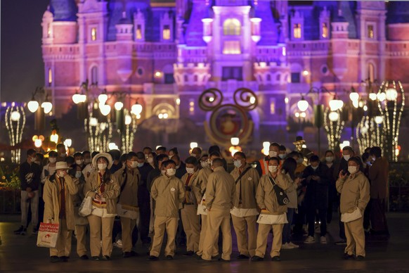 Disneyland employees gather to wait for their COVID-19 tests at the Shanghai Disney Resort in Shanghai, China on Sunday, Oct. 31, 2021. Fireworks boomed as the visitors at Shanghai Disneyland waited f ...