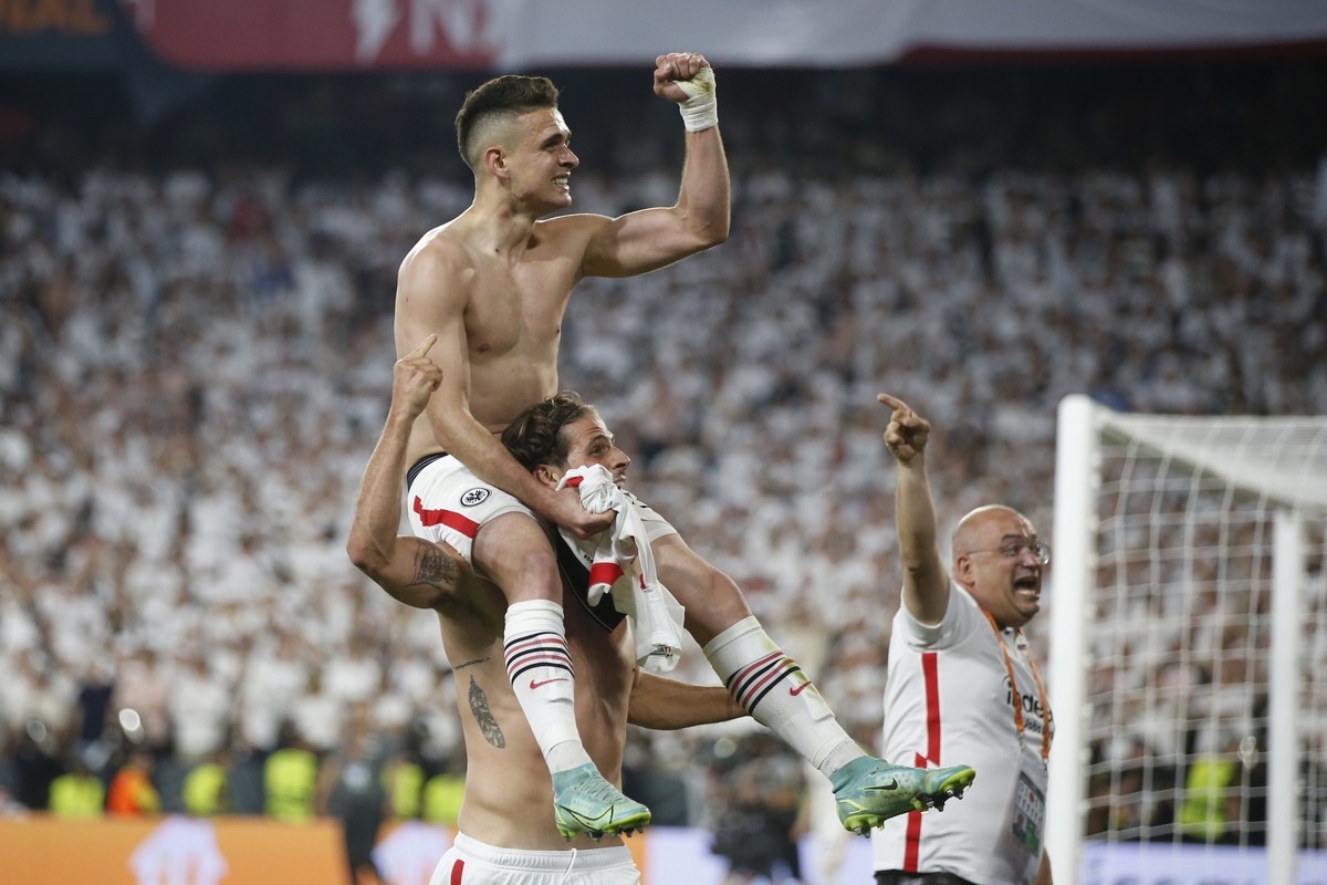 epa09956627 Eintracht's Rafael Santos Borre (up) celebrates with teammates after scoring the decisive penalty during the penalty shootout of the UEFA Europa League final between Eintracht Frankfu ...
