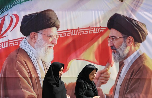 epa12909040 Iranians pass a billboard depicting late Iranian supreme leader Ayatollah Ali Khamenei (L) and his son Iranian supreme leader Ayatollah Mojtaba Khamenei (R) in Tehran, Iran, 23 April 2026. ...