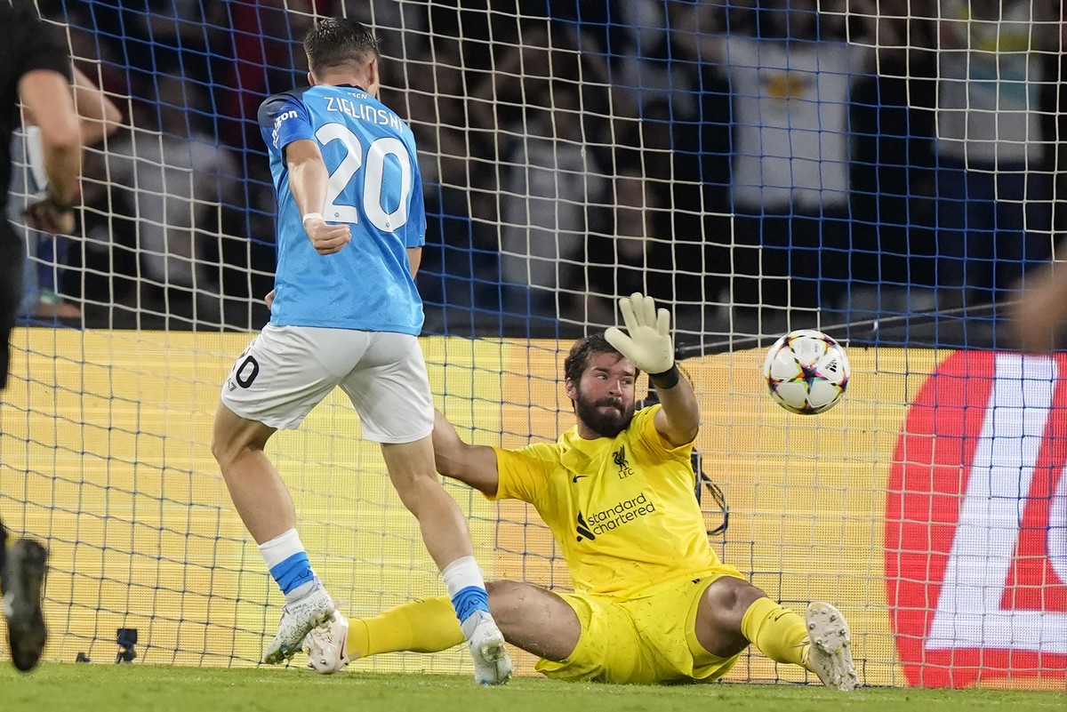 Napoli's Piotr Zielinski, left, scores his side's fourth goal past Liverpool's goalkeeper Alisson during the group A Champions League soccer match between Napoli and Liverpool at the Di ...