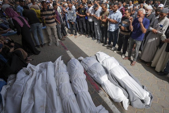 Mourners pray over the bodies of Palestinians who were killed in an Israeli airstrike in Nuseirat, at the Al Aqsa hospital in Deir al Balah, Gaza Strip, Sunday, May 19, 2024. (AP Photo/Abdel Kareem Ha ...