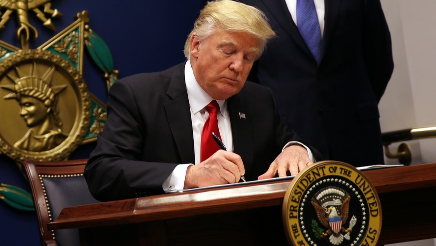 U.S. President Donald Trump signs an executive order to impose tighter vetting of travelers entering the United States, at the Pentagon in Washington, U.S., January 27, 2017. The executive order signe ...