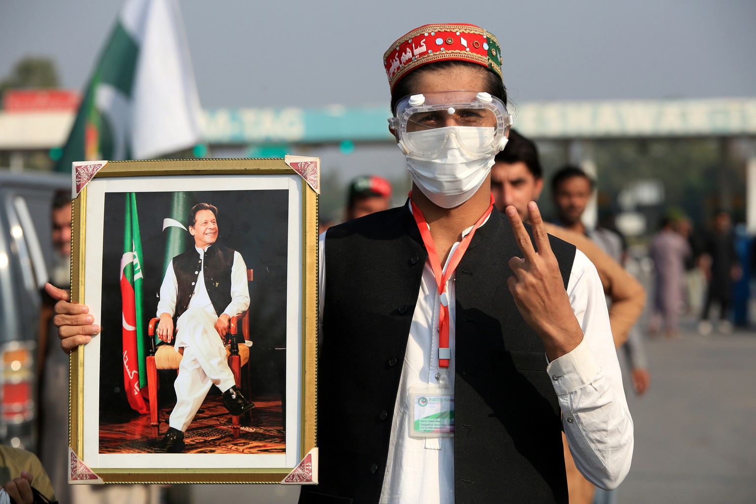 epa11737861 A supporter of the Pakistan Tehreek-e-Insaf (PTI) holds a portrait of the party&#039;s founder and former Prime Minister Imran Khan, as they take part in a rally towards Islamabad to deman ...
