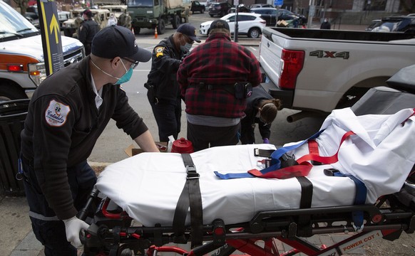 epa08379179 Cataldo Ambulance Services Paramedic Ryan Kelly (L) wheels a gurney behind a patient as Emergency Medical Technician Katie Shikora (R) and Chelsea Police Sergeant Jose Otero (2L) as they a ...