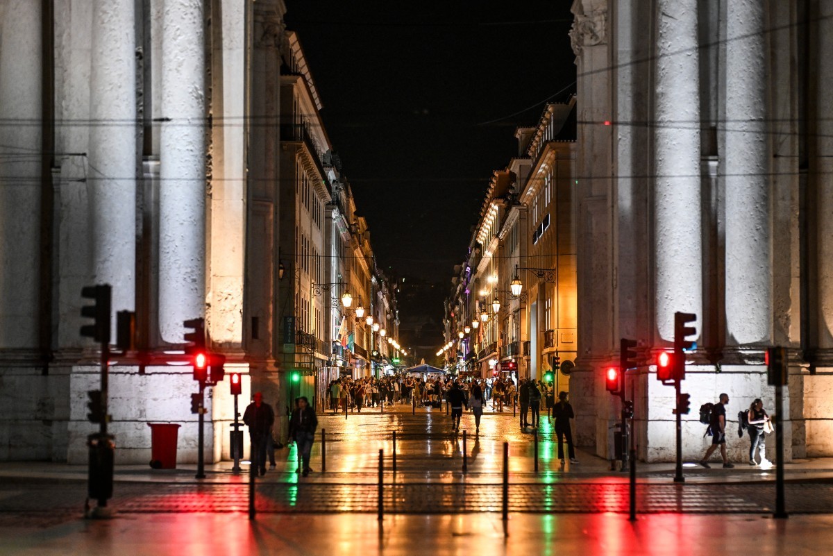 People walk along Rua Augusta after the lights were restored following a massive power cut affecting the entire Iberian peninsula and the south of France, in Lisbon on April 28, 2025. Spanish Prime Mi ...