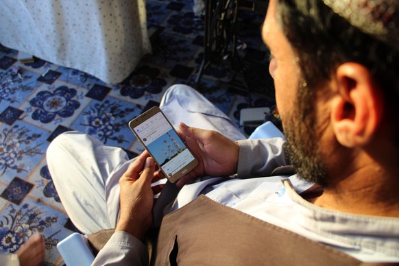 epa12420985 An Afghan man uses a mobile phone as internet and telecom services are gradually restoring after almost three days of closures in Kandahar, Afghanistan, 01 October 2025. Afghanistan restor ...