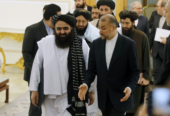 epaselect epa11042835 Iranian Foreign Minister Hossein Amir-Abdoulahian (R) welcomes Afghanistan's Minister of Foreign Affairs Amir Khan Muttaqi (L) and the accompanying delegation in Tehran, Ira ...