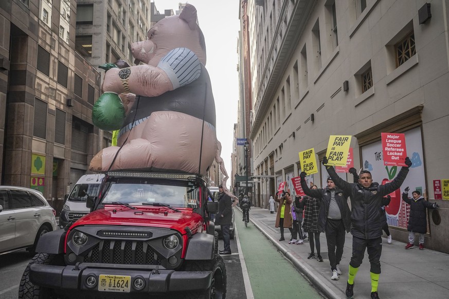 Major League Soccer (MLS) referees and supporters picket outside MLS headquarters around labor&#039;s symbolic &quot;Greedy Pig&quot; balloon, after MLS implemented a lockout against referees followin ...