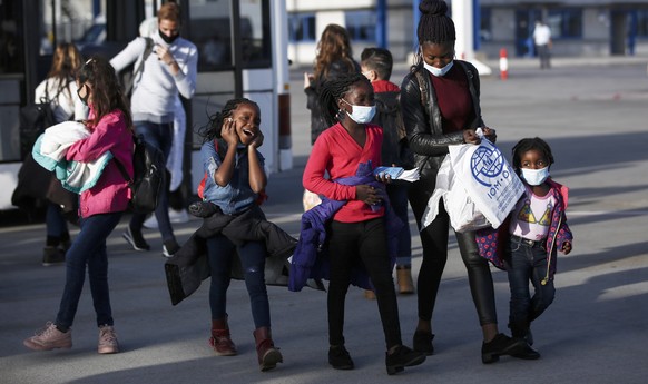 epa08749505 Refugees walk towardsan airplane to travel to Germany, at the International Airport of Athens, Greece, 16 October 2020. 101 refugees in total, who were living at Moria migrant camp on the  ...