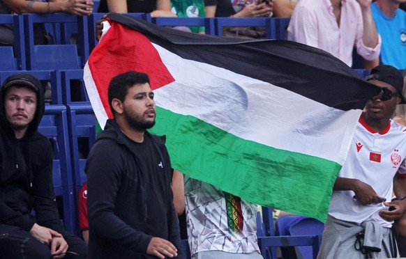 epa11494654 A Mali supporter holds up a Palestinian flag prior the Men Group D match Mali vs Israel of the Soccer competitions in the Paris 2024 Olympic Games, at the Parc de Princes stadium in Paris, ...
