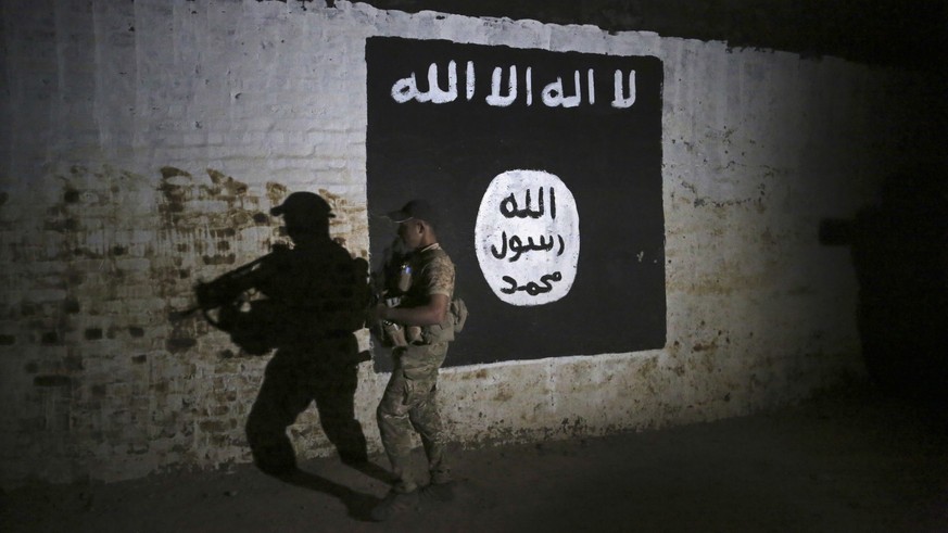 FILE - In this March 1, 2017 file photo, an Iraqi soldier inspects a recently-discovered train tunnel, adorned with an Islamic State group flag, that belonged to the former Baghdad to Mosul line, that ...