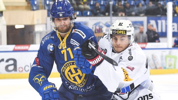 Davos&#039; Claude-Curdin Paschoud, links, gegen Fribourgs Nathan Marchon, beim Eishockey-Qualifikationsspiel der National League A zwischen dem HC Davos und dem HC Fribourg-Gotteron am Dienstag, 2. O ...