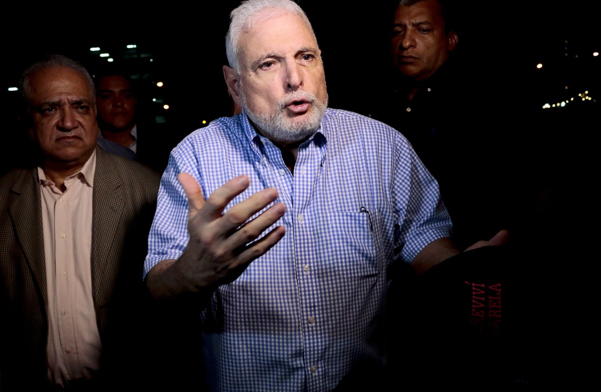 FILE - In this Aug. 9, 2019 file photo, Panama's former President Ricardo Martinelli talks to reporters near his home, in Panama City. A prosecutor in Panama has banned Martinelli on Thursday, Ju ...