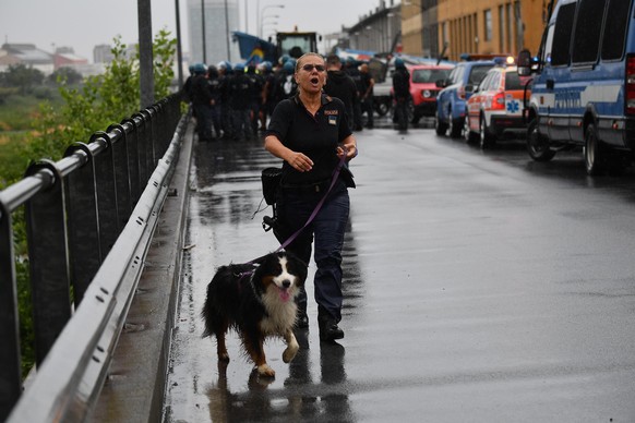 epa06948880 Rescuers at the site of the collapsed bridge in Genoa, Italy, 14 August 2018. A large section of the Morandi viaduct upon which the A10 motorway runs collapsed in Genoa on Tuesday. Both si ...