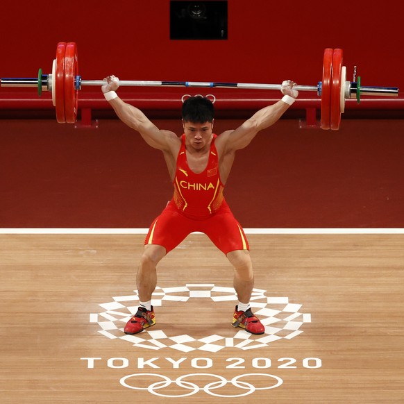 epa09363746 Li Fabin of China in action during the Men&#039;s 61kg - Snatch Group A during the Weightlifting events of the Tokyo 2020 Olympic Games at the Tokyo International Forum in Tokyo, Japan, 25 ...
