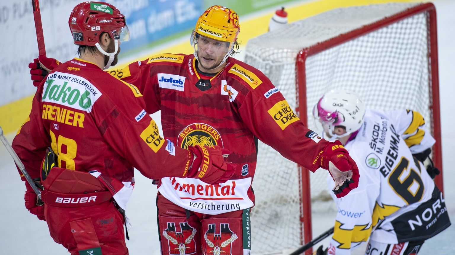 Tigers Alexandre Grenier, links, und Topscorer Jesper Olofsson, rechts jubeln Ajoies Daniel Eigenmann, rechts, geschlagen waehrend dem Qualifikation-Spiel der National League, zwischen den SCL Tigers  ...