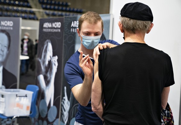 A person receives the COVID-19 vaccine as members of the Aalborg Symphony Orchestra play at the vaccination center in Arena Nord in Frederikshavn, Jutland, Denmark, Monday April 12, 2021. (Henning Bag ...