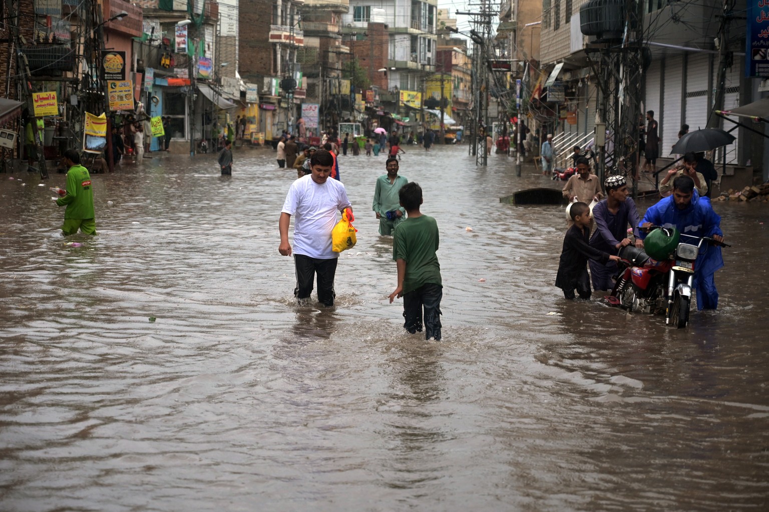 epa13178380 People wade through a flooded street during heavy monsoon rain in Rawalpinidi, Pakistan, 19 August 2026. The Pakistan Meteorological Department (PMD) warned of further rain and thunderstor ...