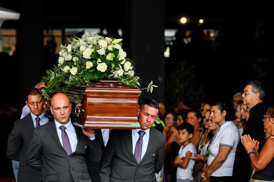 Pallbearers carry a coffin during a funeral service for some of the victims of a collapsed highway bridge, in Genoa&#039;s exhibition center Fiera di Genova, Italy, Saturday, Aug. 18, 2018. Saturday h ...