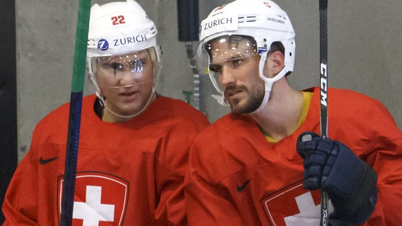 Switzerland&#039;s forward Nino Niederreiter, left, speaks with Switzerland&#039;s defender Roman Josi, 2nd left, past Switzerland&#039;s goaltender Gilles Senn, right, during a training session of th ...