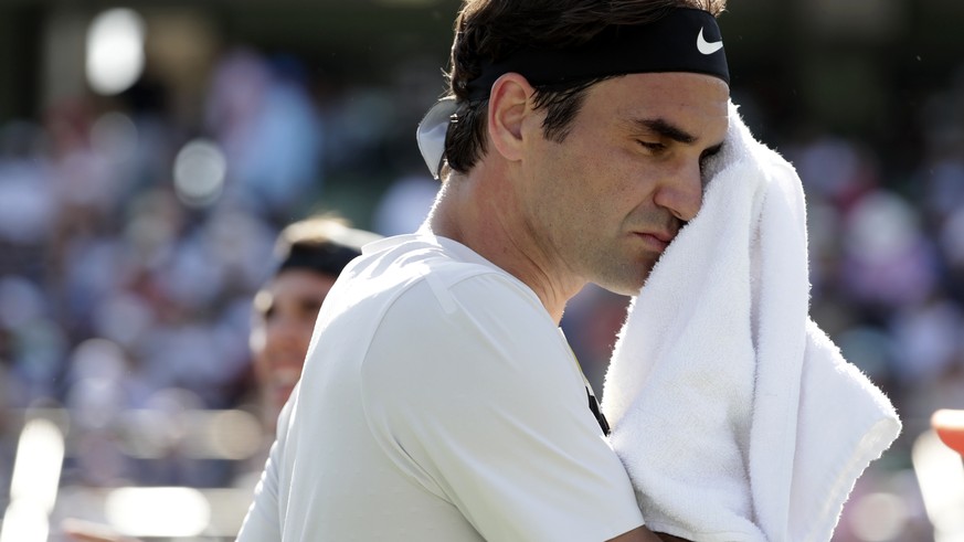 Roger Federer, of Switzerland, wipes his face during his match against Thanasi Kokkinakis, of Australia, at the Miami Open tennis tournament, Saturday, March 24, 2018, in Key Biscayne, Fla. (AP Photo/ ...