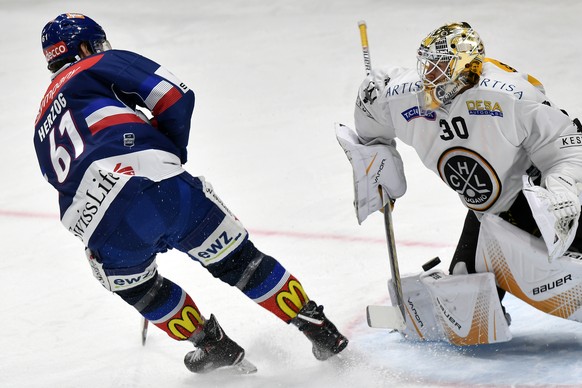 Der Zuercher Fabrice Herzog, links, scheitert am Tessiner Torhueter Elvis Merzlikins, rechts, beim Eishockeyspiel der National League ZSC Lions gegen den HC Lugano im Hallenstadion in Zuerich am Diens ...