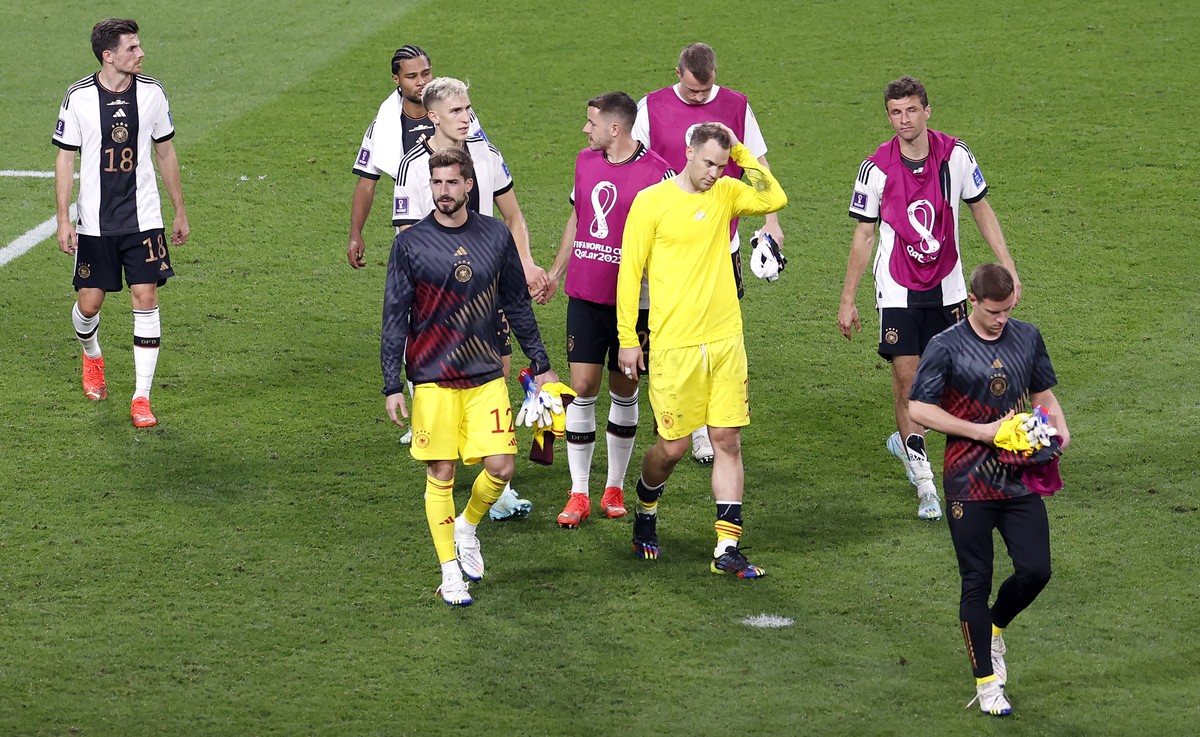 epa10322857 Goalkeeper Manuel Neuer of Germany and teammates walk off the pitch after the FIFA World Cup 2022 group E soccer match between Germany and Japan at Khalifa International Stadium in Doha, Q ...