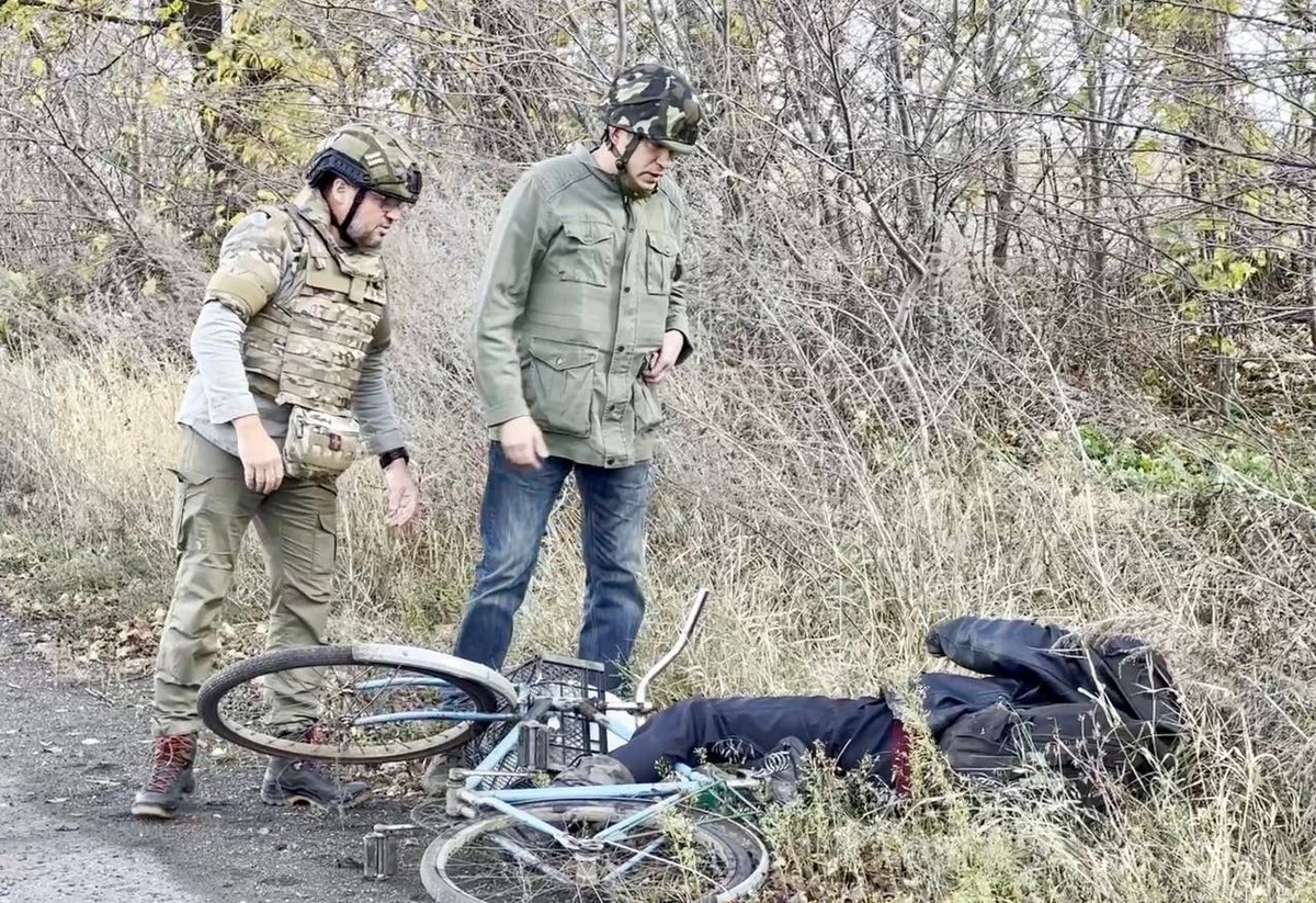 Ein Velofahrer liegt neben der Strasse, mitten im Kampfgebiet.