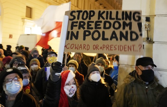 People demonstrate after the Polish parliament approved a bill that is widely viewed as an attack on media freedom, in Warsaw, Poland, Sunday Dec. 19, 2021. Poles flocked to city centers across the co ...