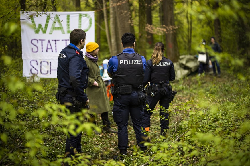Einsatzkraefte der Polizei im Gespraech mit Aktivisten die ein Waldstueck nahe der Deponie Chalberhau im Ruemlanger Wald besetzen, am Samstag, 8. April 2023 in Ruemlang. Rund 20 Aktivisten protestiere ...